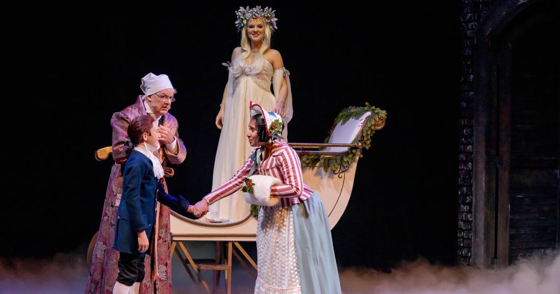 (Front) Michael Wood (Boy Scrooge), Chaarvi Iyengar (Fan), (back) Andrew May (Ebenezer Scrooge) and Maggie Lou Rader (Ghost of Christmas Past) in A CHRISTMAS CAROL at Cincinnati Playhouse in the Park. Photo by Mikki Schaffner.