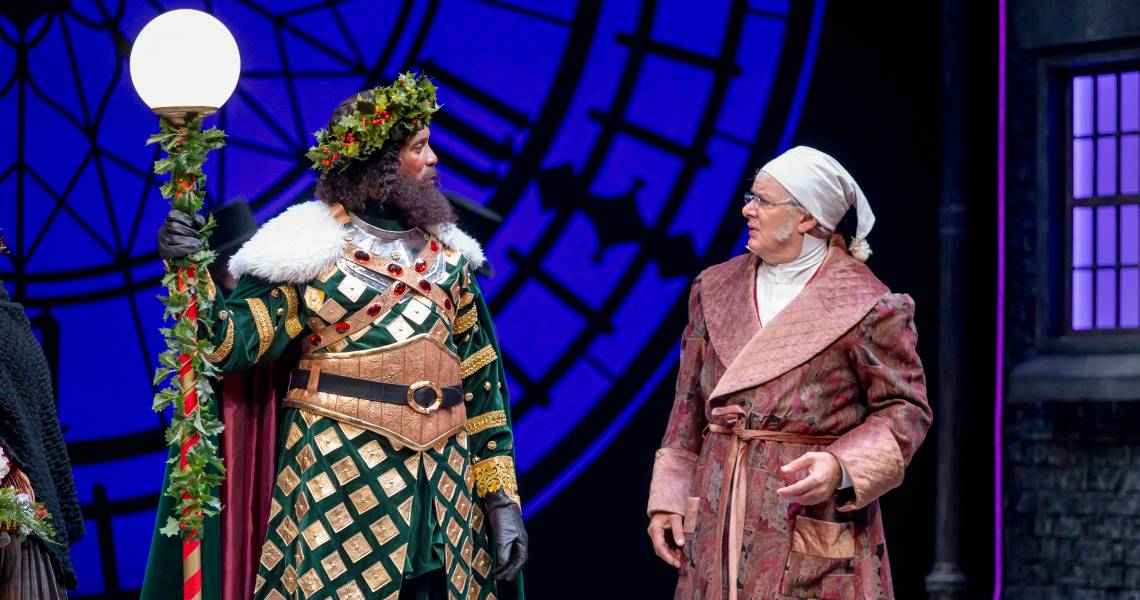 Kenneth Early (Ghost of Christmas Present) and Andrew May (Ebenezer Scrooge) in A CHRISTMAS CAROL at Cincinnati Playhouse in the Park. Photo by Mikki Schaffner.