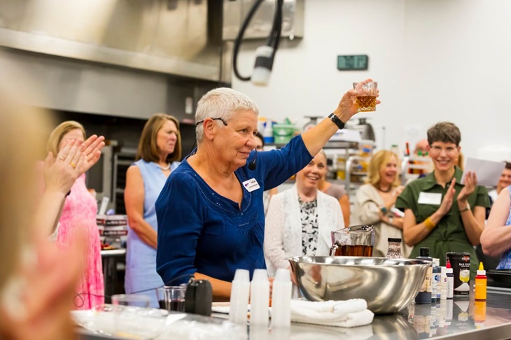 Rosenthal Shelterhouse Properties Crew Lead Deb Hildebrand demonstrates making faux alcohol at the August 2024 event.